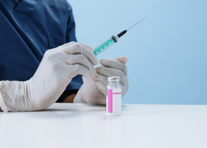 doctor holding an injection and wearing disposable gloves