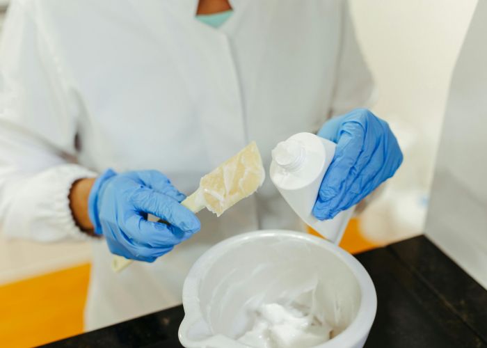 woman wearing nitrile gloves while adding chemical to a tube